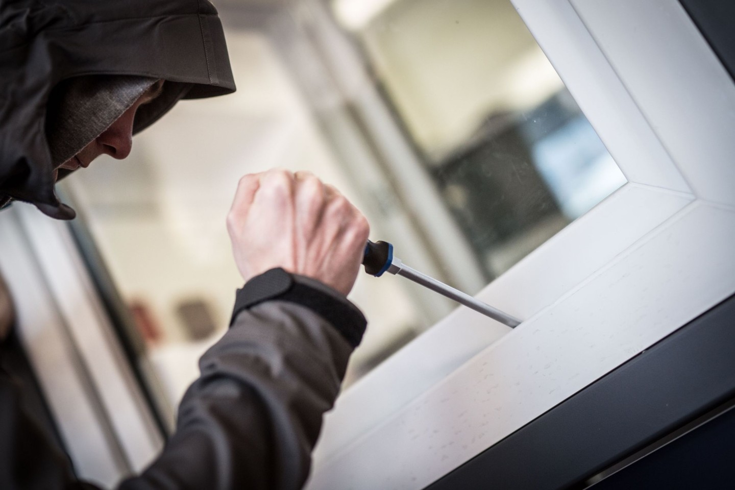 Ein Mann demonstriert in einer polizeilichen Beratungsstelle, wie Einbrecher Fenster aufhebeln. (Illustration)