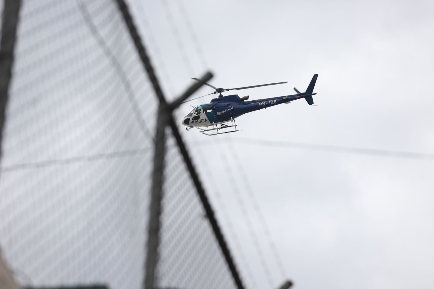 Ein Hubschrauber fliegt über dem Zaun des Gefängnisses Inca im Norden von Quito.