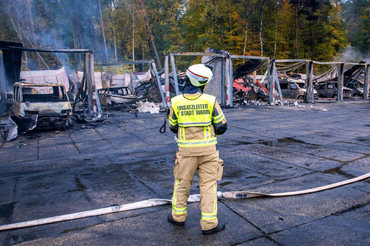 Feuerwehrleute löschen letzte Brandherde nach einem Feuer auf dem Gelände der Feuerwehr in Warin.