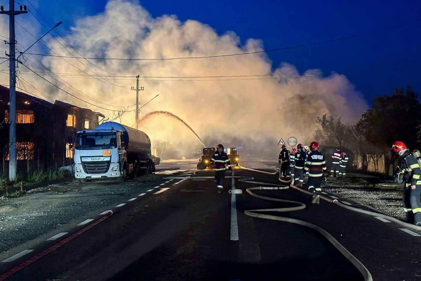 Feuerwehrleute bei Löscharbeiten nach einer Explosion an einer Tankstelle für Flüssiggas (LPG).